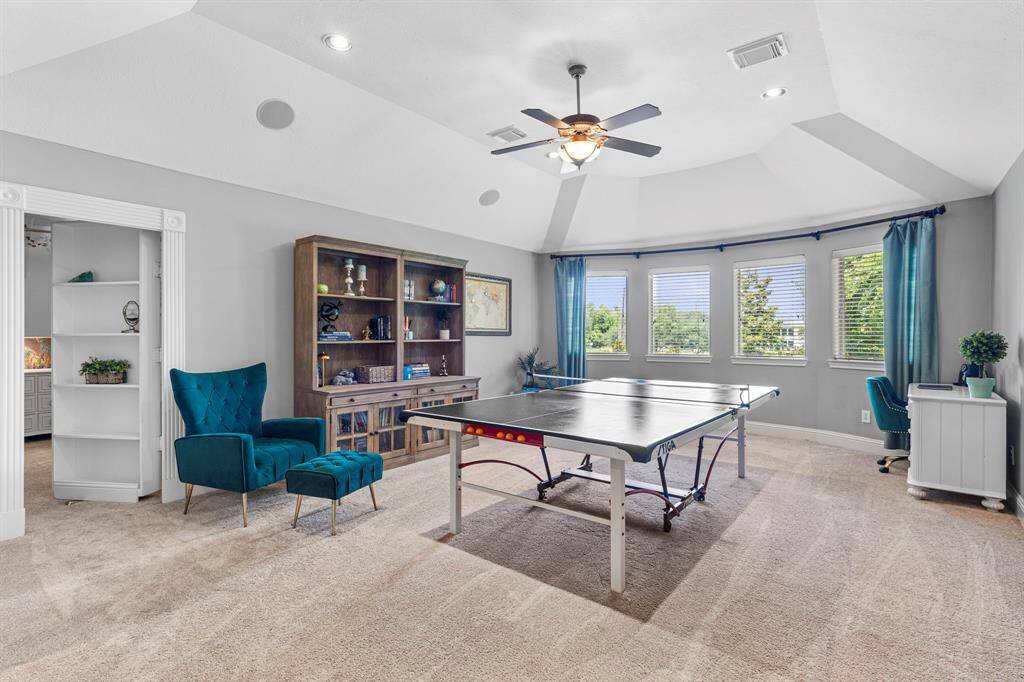 The upstairs game room features plush carpet, high ceilings, large windows, and secret door!