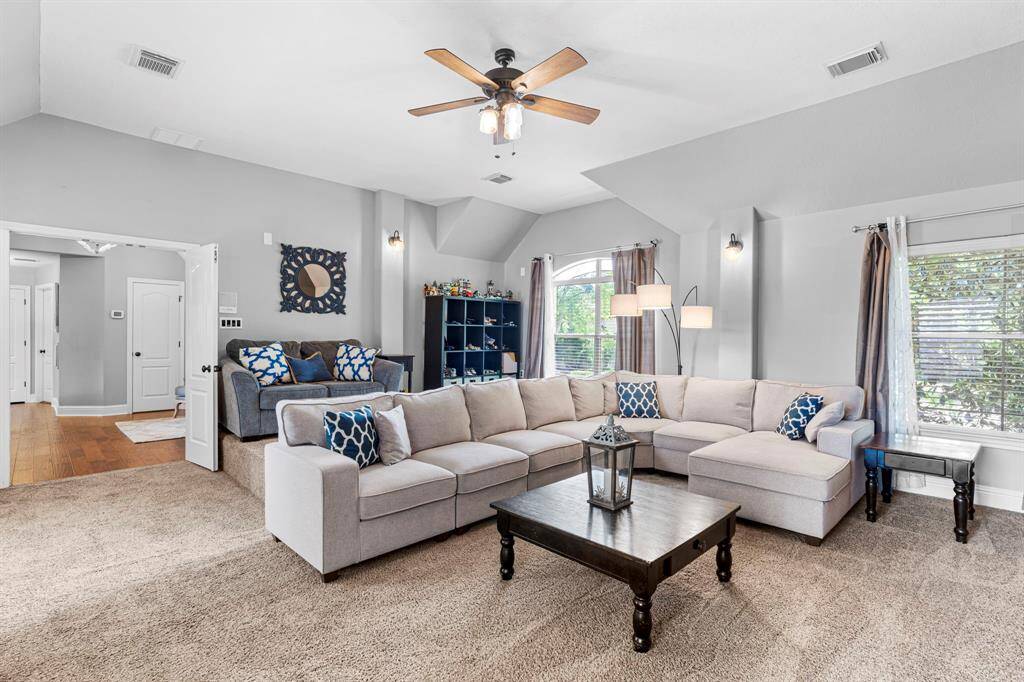 The media room features plush carpet, custom paint, high ceilings, and large windows.