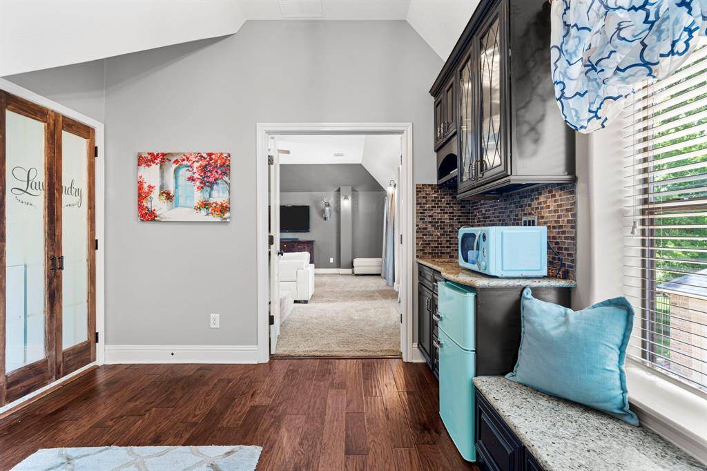 The wet bar has dark cabinets and spacious countertops.