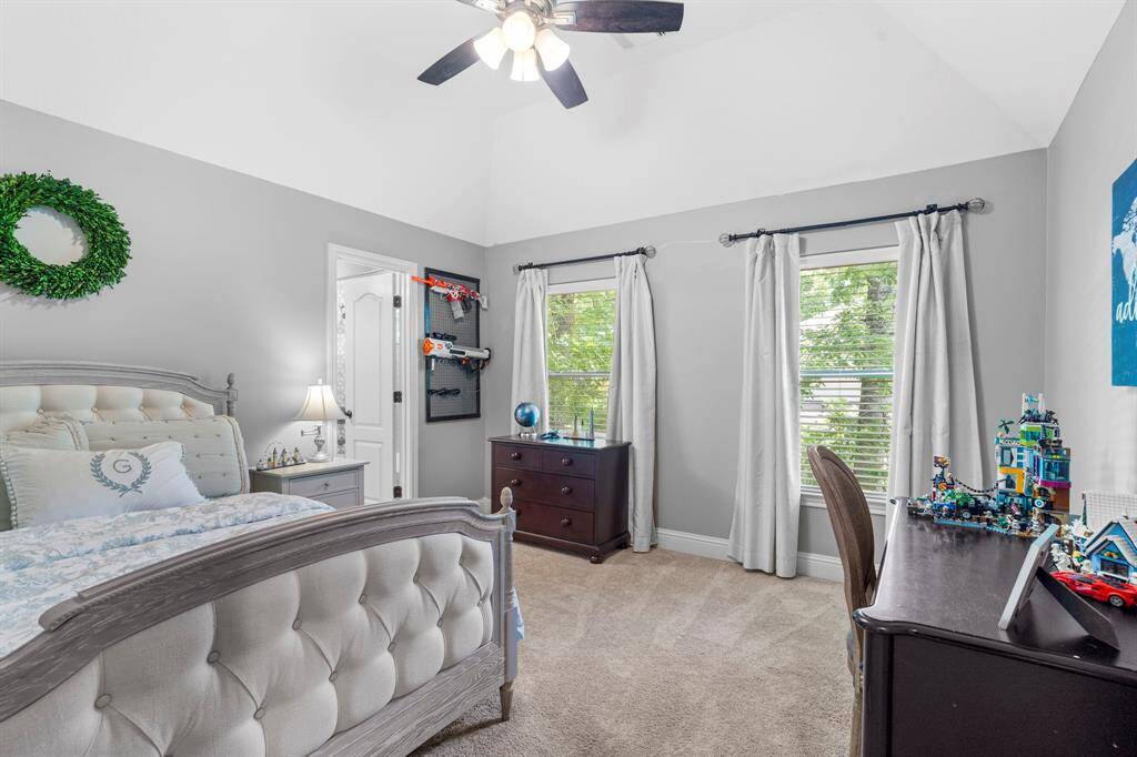 Secondary bedroom features large windows, ceiling fan, custom paint, and plush carpet.