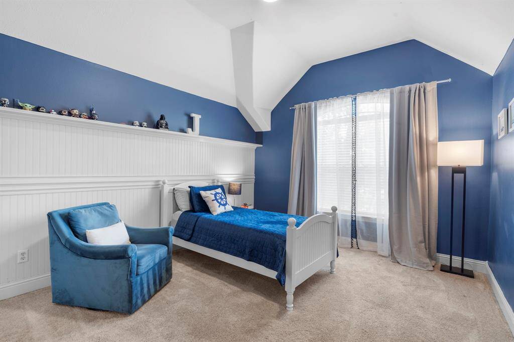 Fourth bedroom features a large window, built-in shelving, custom paint, and plush carpet.