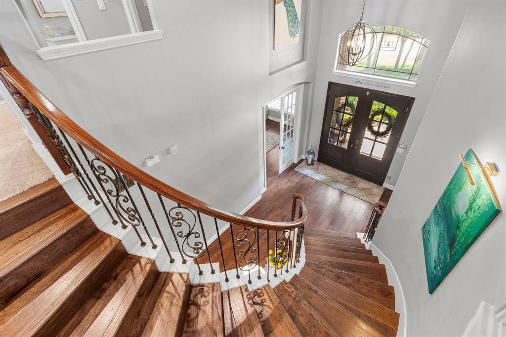 The entryway has a spiral staircase with iron railing details.