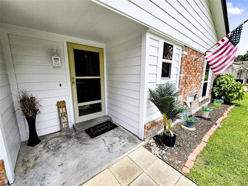 Charming front entrance with a covered porch and welcoming decor.The brick and siding exterior adds character.
