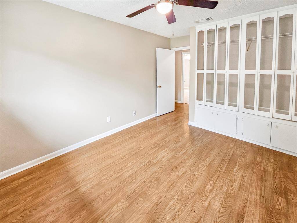 Second bedroom with ceiling fan light fixture and plenty of storage
