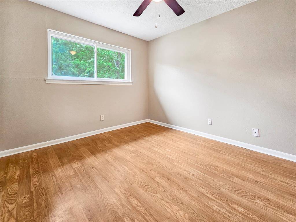 Third bedroom with ceiling fan light fixture, plenty of natural light