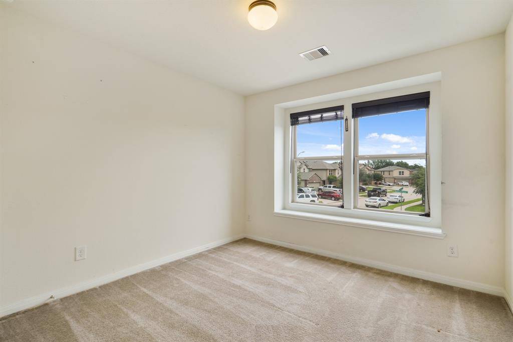 Secondary bedroom with carpet floors, and large windows.