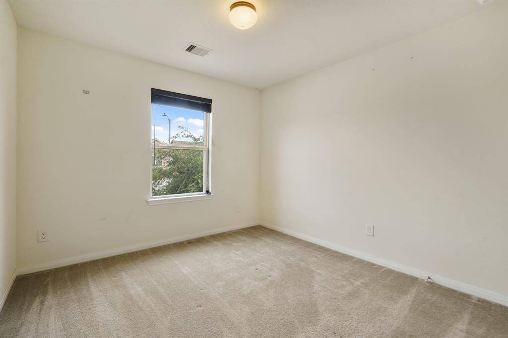 Secondary bedroom with carpet floors, and neutral paint.