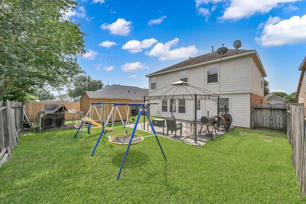 Fully fenced backyard features an extended patio, shed, and separate fenced dog area