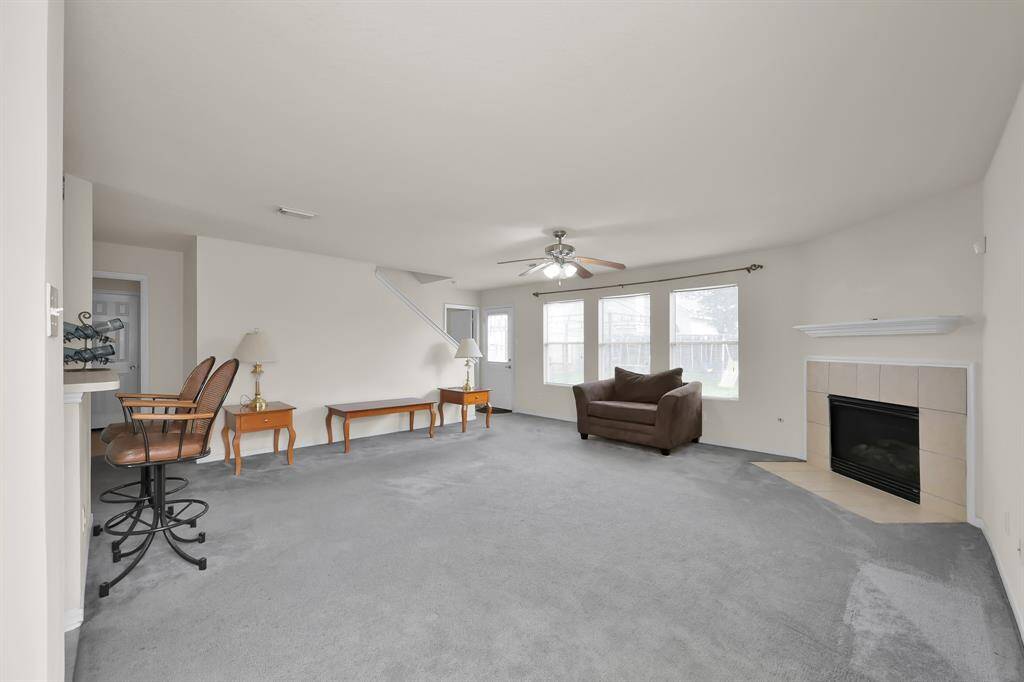 Spacious living room with a cozy fireplace and overlooking the backyard