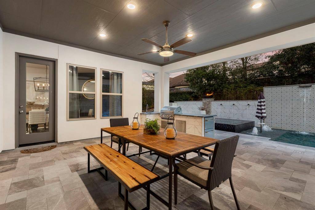 Covered patio off the full sliding glass wall is larger than it shows here.  Wired for outdoor TV, wall mount conveys with the sale.  Sellers had a table of the size pictured here as well as a wicker 3 seat sofa and swivel chair.