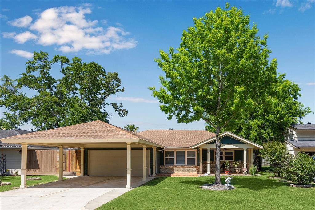 Charming traditional-style home in the heart of Spring Branch, featuring a spacious driveway and covered carport.
