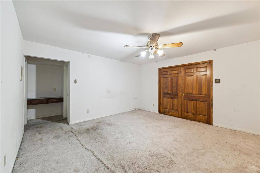 Primary bedroom with ensuite bathroom and walk-in closet, double doors lead to sunroom