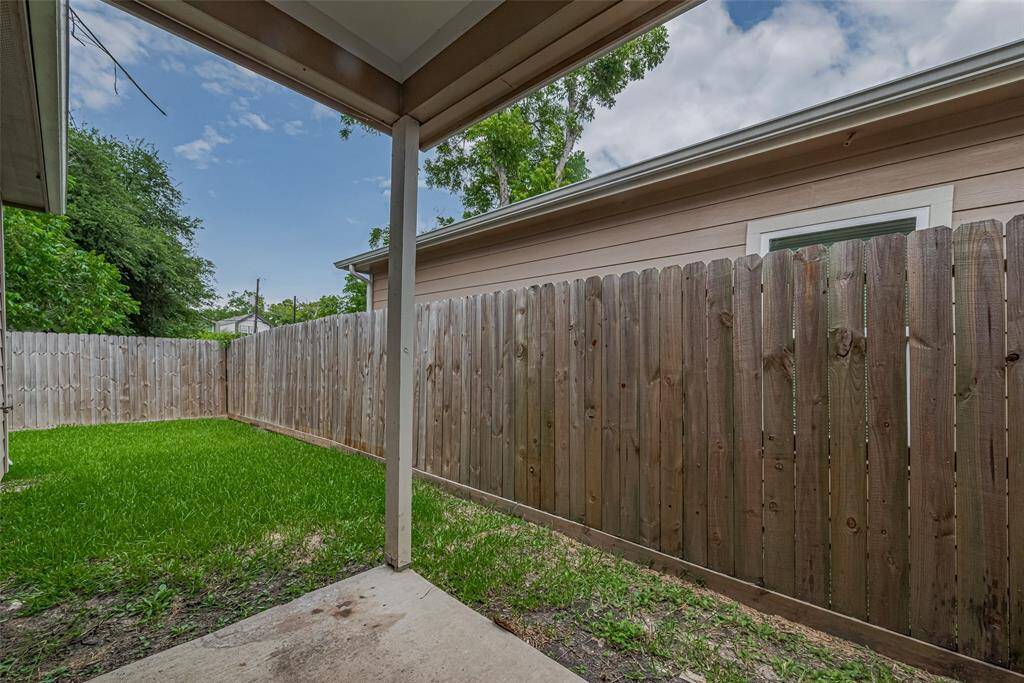 Covered concrete back yard patio and lush green grass, providing a private outdoor space ideal for relaxation or small gatherings, and the mornings coffee cup.