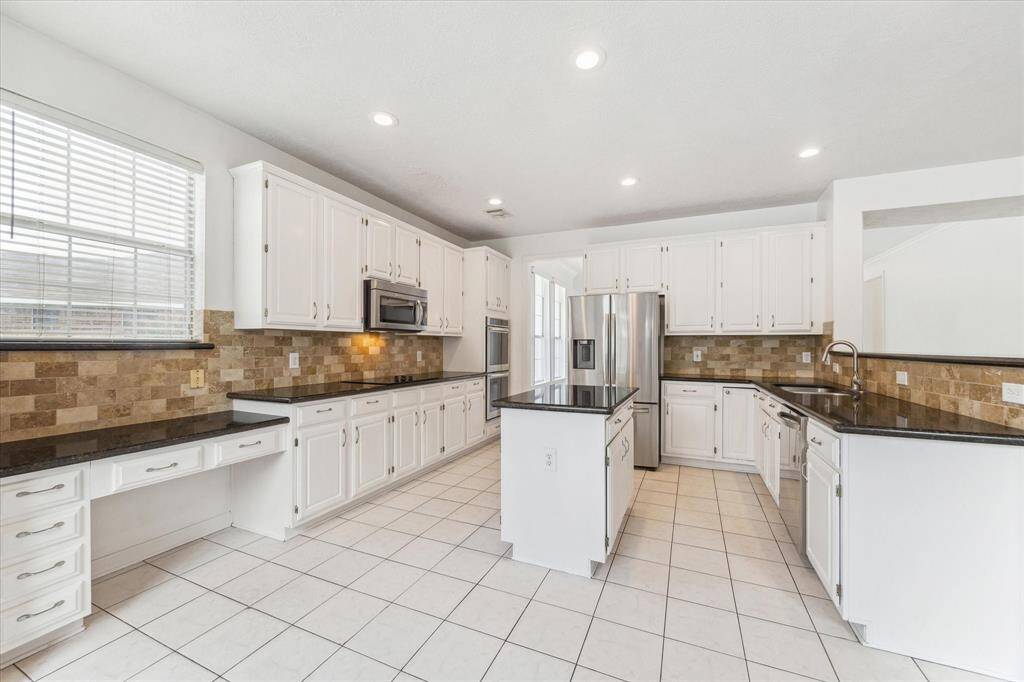 CHEF-INSPIRED KITCHEN FEATURING GRANITE COUNTERS, SUBWAY TILE BACKSPLASH, DOUBLE OVENS, AND A CENTER ISLAND. BRIGHT, CLEAN, AND READY FOR ENTERTAINING.