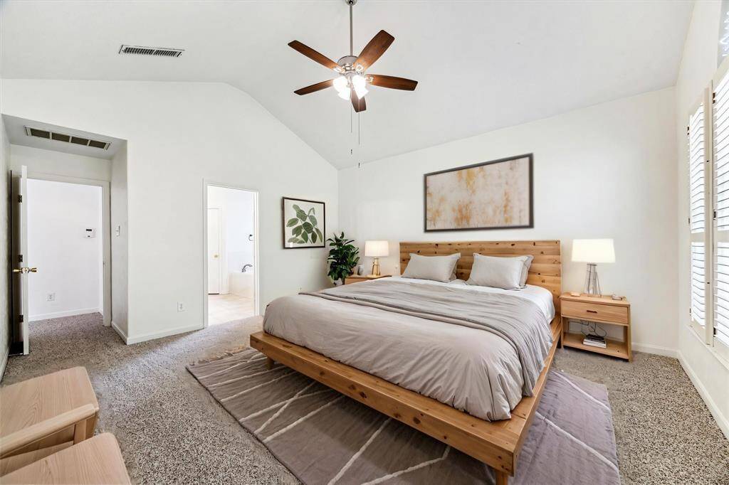 PRIMARY SUITE FEATURES CARPET FLOORING, SOARING CEILINGS, AND DIRECT ACCESS TO THE EN-SUITE BATHROOM. **This room has been virtually staged.