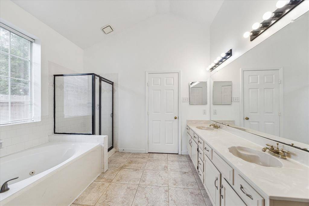 PRIMARY BATHROOM WITH DUAL VANITIES, A JETTED SOAKING TUB, WALK-IN SHOWER, AND PLENTY OF STORAGE—YOUR PRIVATE SPA RETREAT.