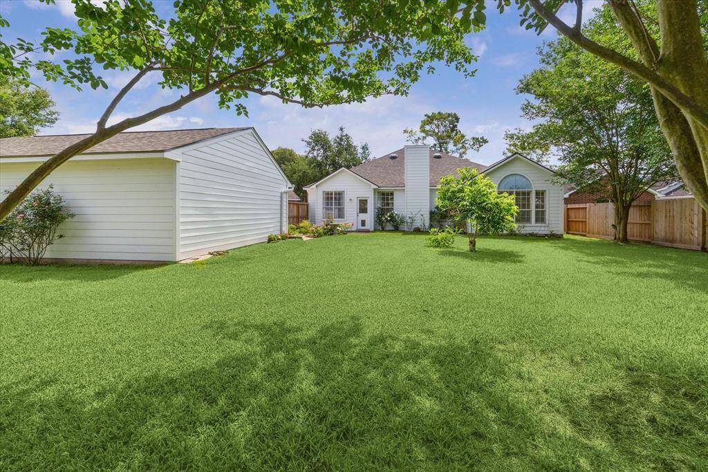 FROM THIS ANGLE, THE HOME'S NEWLY INSTALLED SIDING SHINES BRIGHT WITH BEAUTIFULLY LANDSCAPED BACKYARD.