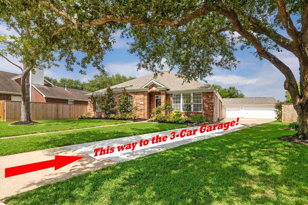 WIDE VIEW OF HOME WITH 3-CAR GARAGE WITH A LONG DRIVEWAY AND SHADED FRONT YARD. NEW SIDING AND NEW ROOF STAND OUT.