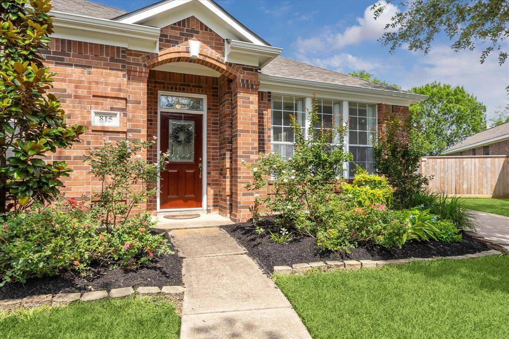CHARMING FRONT PORCH WITH ARCHITECHTURAL BRICK ARCHWAY.