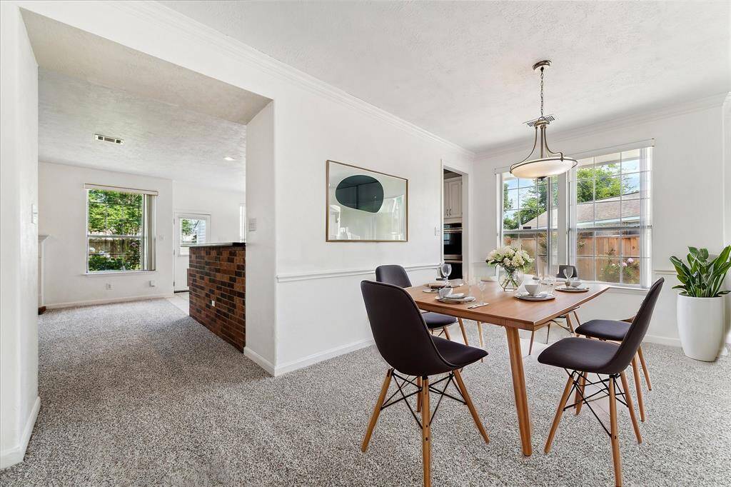 DINING ROOM OPEN TO THE KITCHEN, FEATURING A CLASSIC CHANDELIER AND DOUBLE WINDOWS. **This room has been virtually staged.