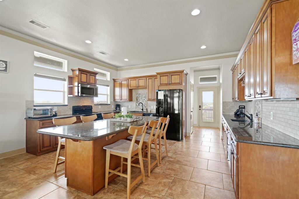 Additional counter space with a second sink, wine glass rack, and mosaic tile accent—perfect for prepping drinks or morning coffee.