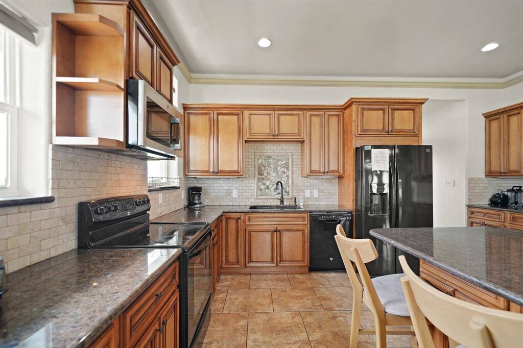 Spacious layout with under-cabinet lighting, custom tilework, and plenty of upper and lower storage.