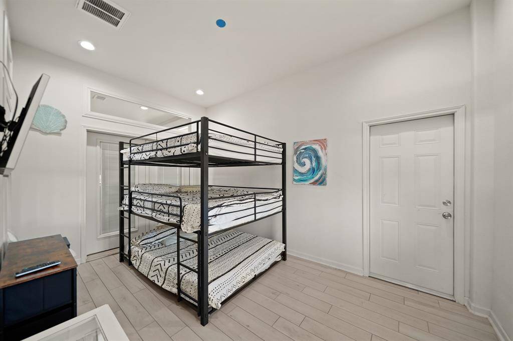 This bunk room features triple-stacked beds and durable flooring—perfect for hosting large groups or maximizing rental income.