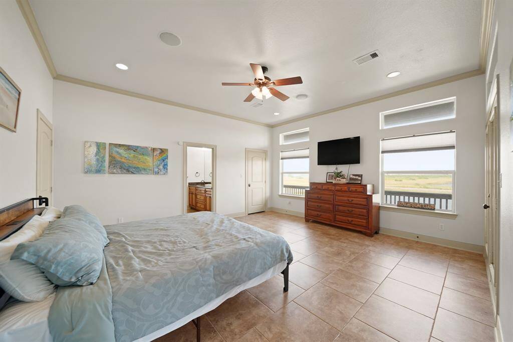 The luxurious primary suite offers serene coastal views, private balcony access, and direct entry to the ensuite bath.