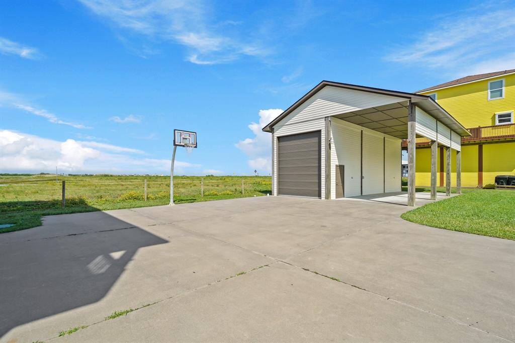 This home is built for both form and function with ample concrete driveway space, elevated construction for storm safety, and a large detached garage perfect for storing beach gear, boats, or even converting into a bonus rec space.