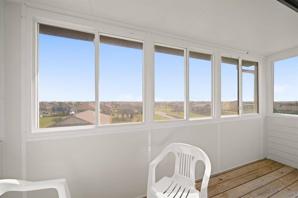 Another angle of the serene screened-in patio with elevated views of nearby marshland and waterways.