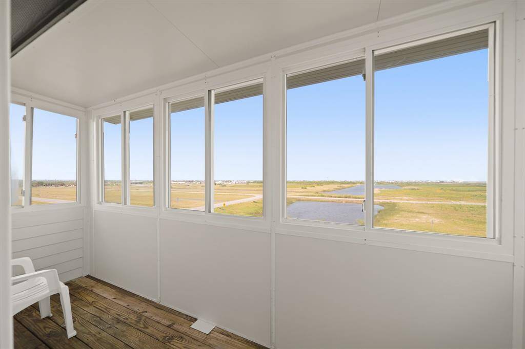 Enjoy year-round breezes and views from this enclosed patio—ideal for relaxing with a book or your morning coffee.