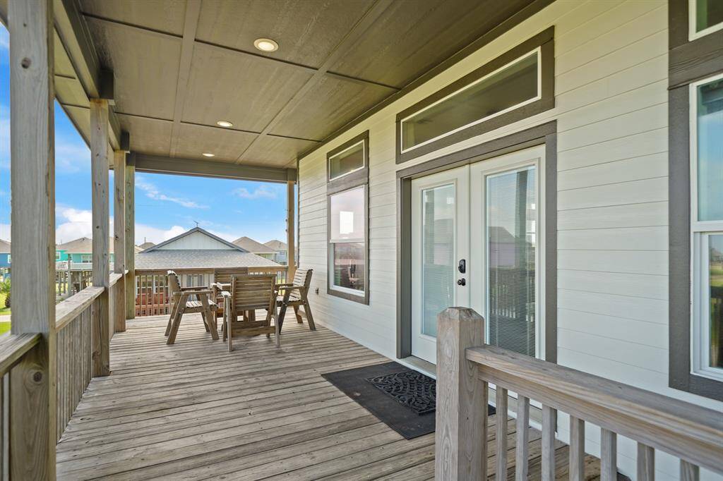 The front deck provides neighborhood views with colorful beach homes, while the back deck overlooks tranquil open land and a peaceful waterway.