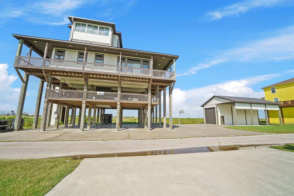 Elevated construction with room for multiple vehicles, boats, or RVs and additional detached storage.