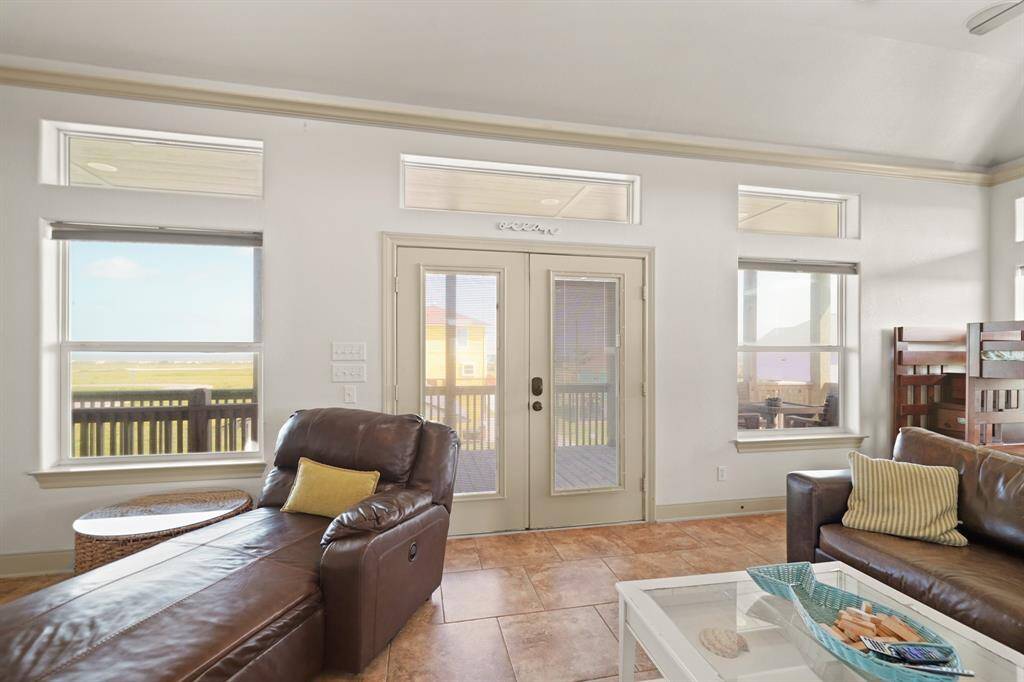 Wall-to-wall windows and glass doors flood the space with natural light while offering tranquil views of the surrounding landscape.