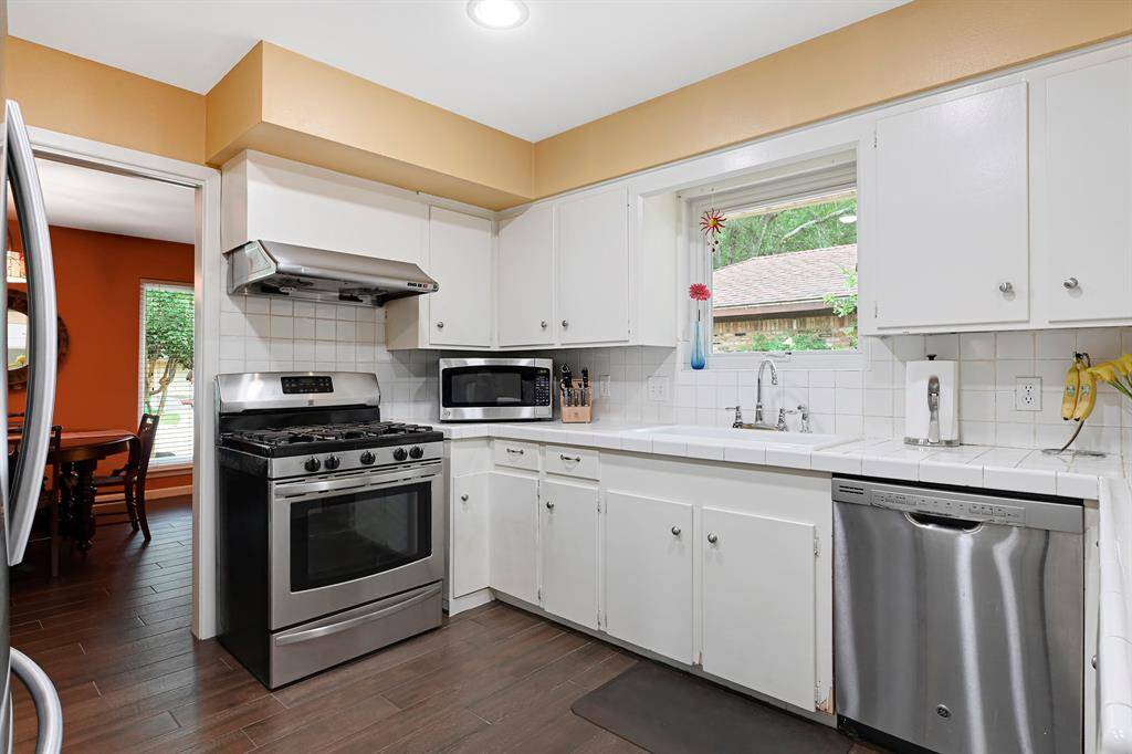 The kitchen features recessed lighting, stainless steel appliances - including a gas stove - and a pantry. A window  offers natural lighting, and the space also connects to a dining area.