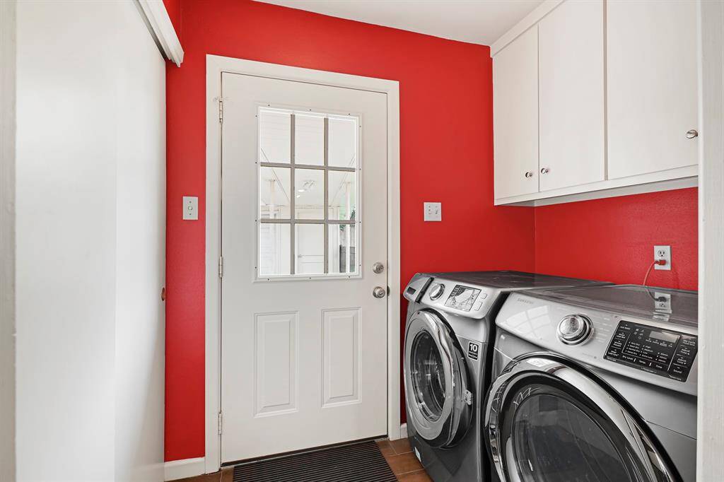 The Utility Room offers ample storage with cabinetry above and additional space along the opposite wall. The back door opens to a covered walkway leading to the garage and backyard. The Washer and dryer are included!