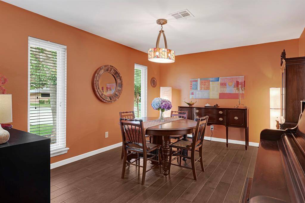 The Spacious Dining Room features a gorgeous ornate glass Chandelier, warm walls, and ample natural lighting from two large windows. A relaxing atmosphere for Family Dinners and Entertaining.