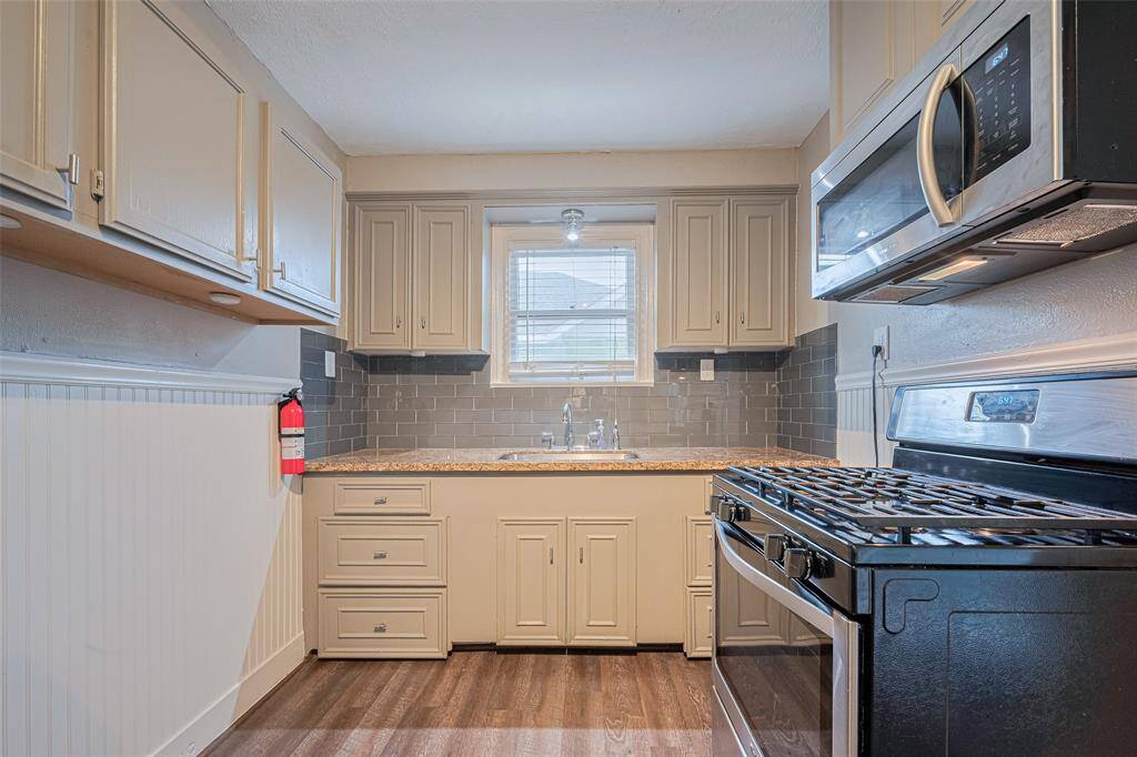 Kitchen equipped with a gas stove and full sized fridge