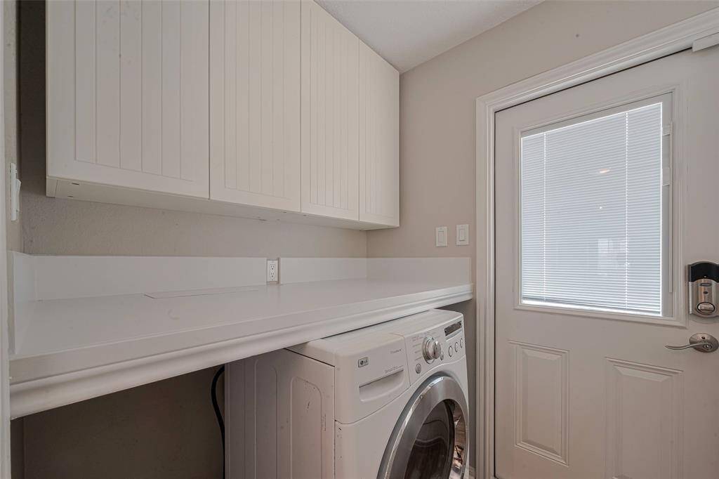 The large laundry room has storage above the washer/dryer and behind the door.