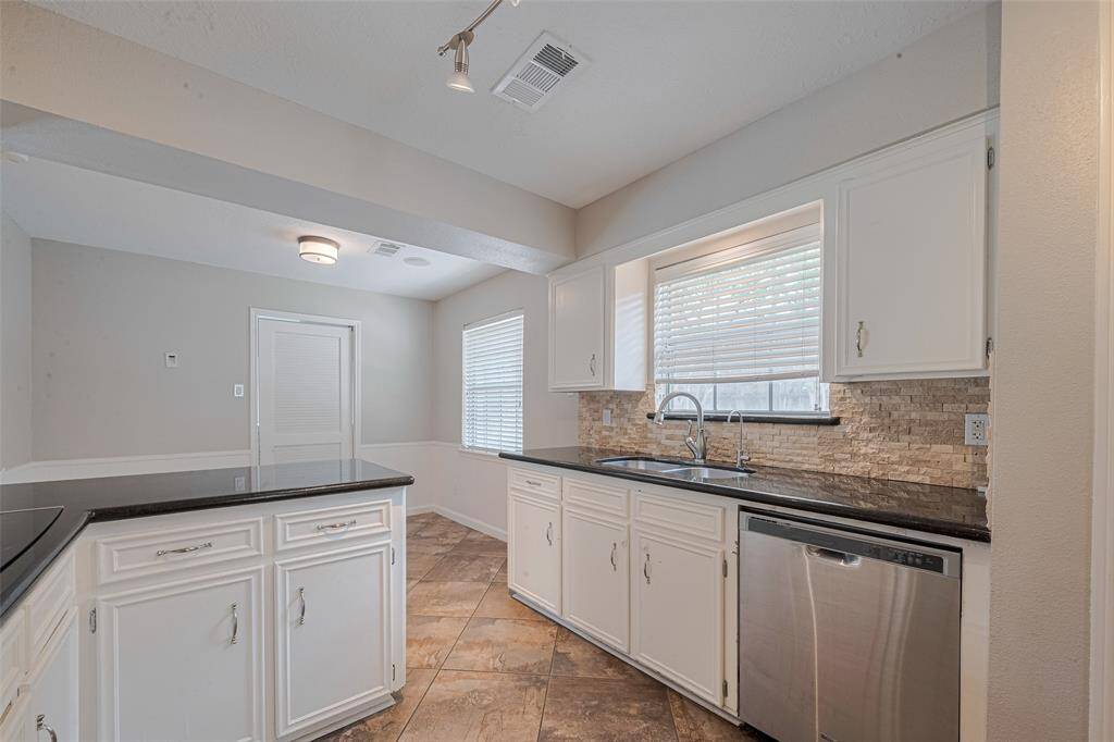 Kitchen is updated with granite countertops and stone backsplash.