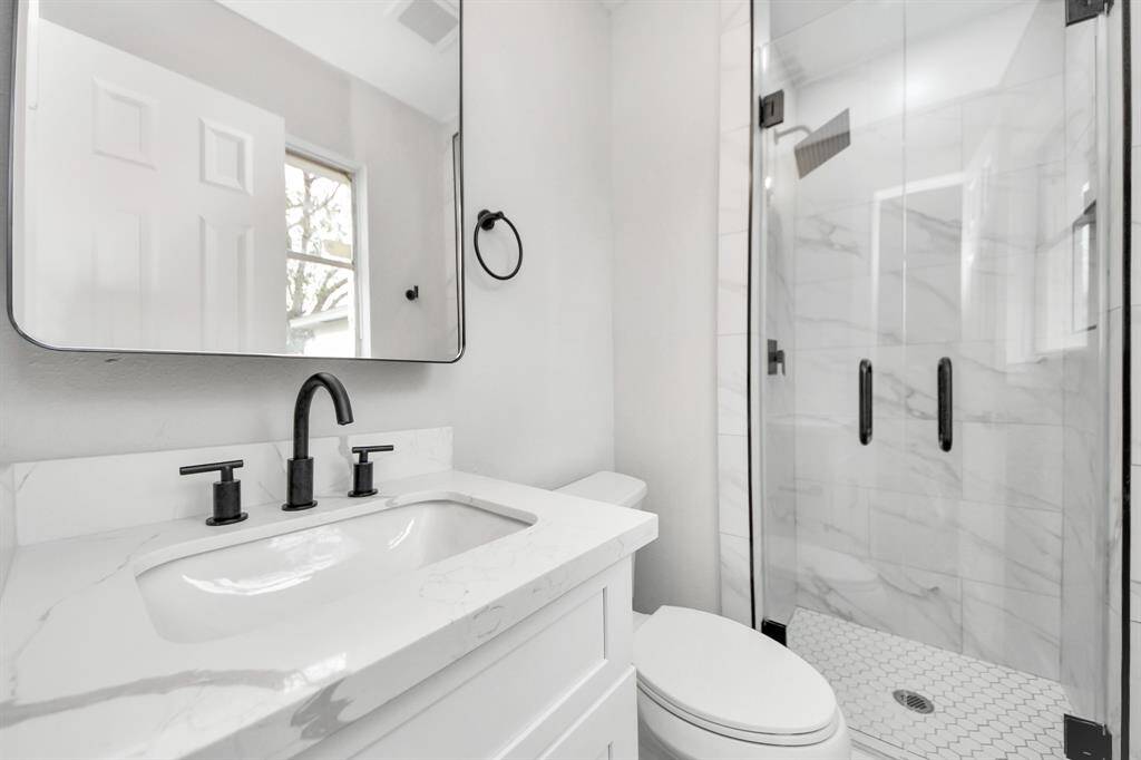 A complete bathroom remodel featuring brand-new flooring, a sleek tub, a new toilet, upgraded shower fixtures, new cabinets with handles installed, Quartz countertops, a fresh sink, and all-new plumbing hardware. Plus, don’t miss those stunning framed mirrors and eye-catching light fixtures!Shower glass door and shower base are also new. Medicine cabinet included!
