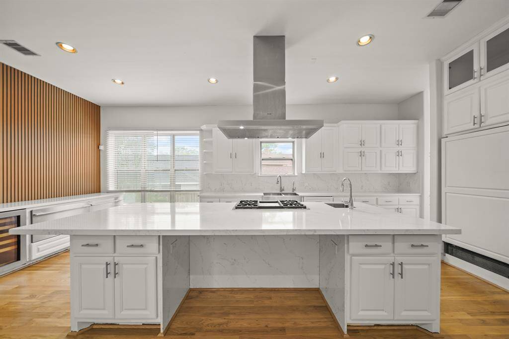 The Epicurean Kitchen touts a Quartz Topped Island/Breakfast Bar with Bosch Stainless Steel Microwave, Undermount Stainless Steel Vegetable Prep Sink, Polished Chrome Faucet with Pull Out Spray, and White Painted Cabinets and Drawers.