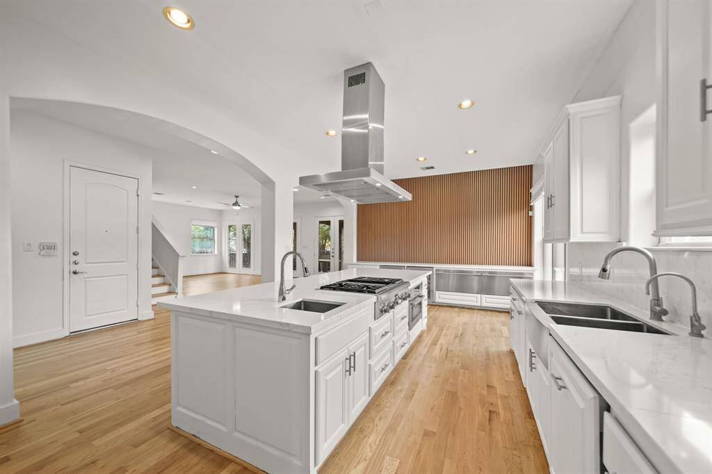 This Stylish Kitchen also features Quartz Counters with Backsplash, White Painted Raised Panel Soft Close Cabinets/Drawers, and Glass Front Upper Cabinets.  Additional Amenities include a Stainless Steel Farmhouse Sink with 2 Basins, Polished Nickel Goose Neck Faucet with Pull Out Spray, and Separate Polished Nickel Filtered Water Dispenser.