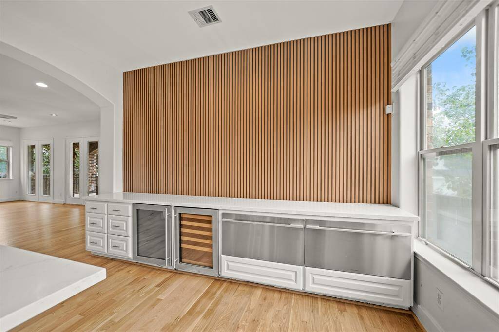 A Quartz Topped Elongated Serving Bar (Approximately 13'5" x 2'3") with White Painted Raised  Panel Cabinets is Perfect for serving Special Buffet Meals!  Two Fisher & Paykel Stainless Steel Pull Out Freezer Drawers provide Additional Space for Frozen Items.  You'll also enjoy the Convenience of Two Stainless Steel Wine/Beverage Refrigerators!