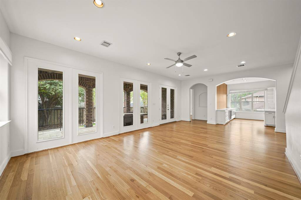The Living Area features Brand New (April 2025) Refinished Natural Hardwood Floors, 2 Sets of Stationary French Style Glass Doors that view the Covered Living Area and the Landscaped Backyard.  Double French Style Glass Patio Doors open to the Covered Outdoor Living Area and the Landscaped Backyard.