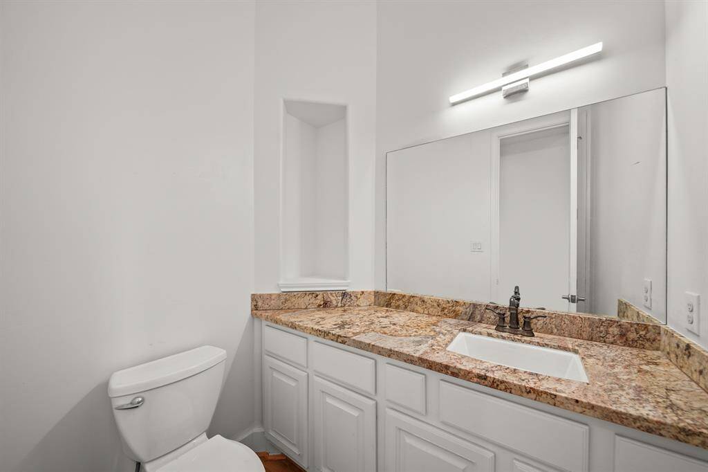 The Half Bath/Powder Room features a Granite Topped Vanity, Undermount White KohlerPorcelain Sink, Oil Rubbed Bronze Faucet, White Painted Raised Panel Cabinets & Drawers, Light Fixture with Opaque Glass Shades, Art Niche, Oil Rubbed Bronze Towel Ring, Brand New (April 2025) Refinished Natural Hardwood Floors, and Fresh Designer Paint.
