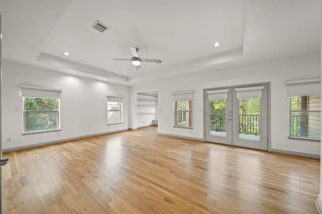 The Oversized Primary Suite (Approximately 26'8" x 15'10") is located on the Second Floor and boasts a French Door that opens to a Spacious Balcony. Amenities in the Primary Bedroom include a Raised Trey Ceiling and Brand New (April 2025) Refinished Natural Hardwood Floors.