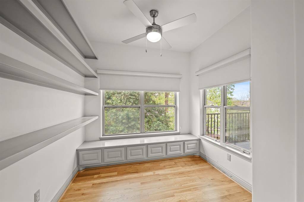 The Well Designed Office/Flex Room features Brand New (April 2025) Refinished Natural Hardwood Floors, Fresh Designer Paint, Wall to Wall Built in Shelves, Built in Window Seat (with Storage Cabinets below), Fabric Roller Shades, and a Ceiling Fan with Light.  Side by Side Windows view the Balcony and the Landscaped Backyard.  The Office/Flex Room is located Adjacent to the Primary Bedroom---How Convenient is That!
