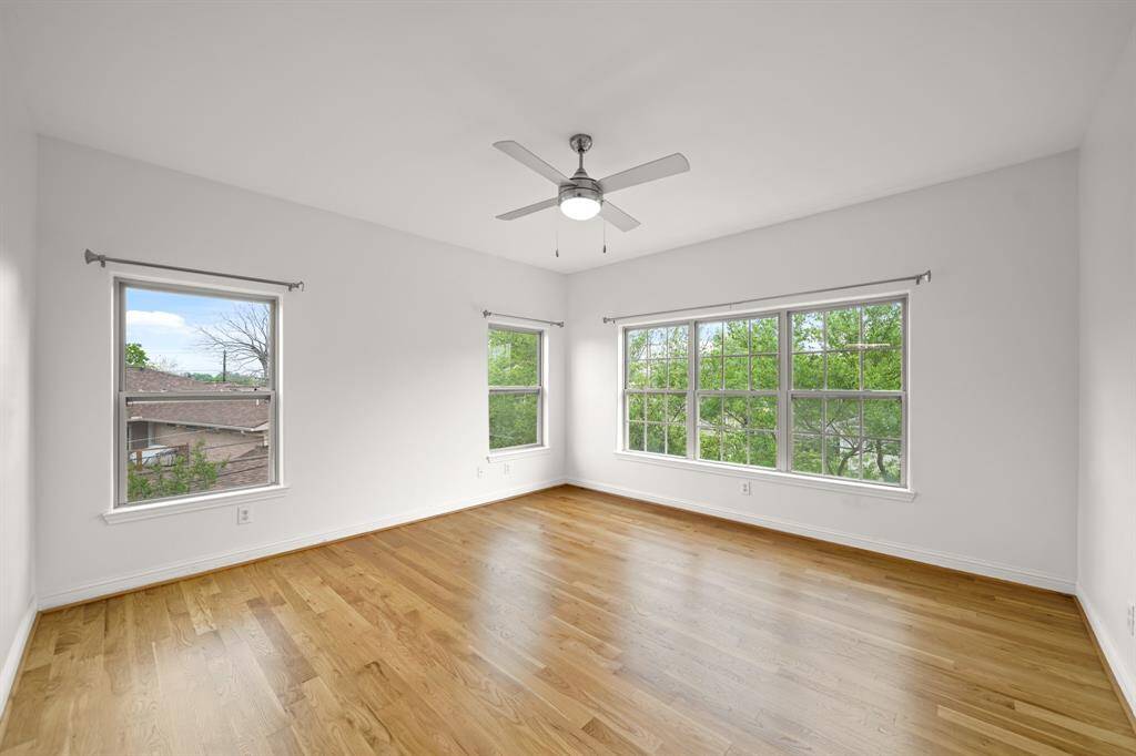 The Second Bedroom is Ensuite and features a Ceiling Fan with Light, Brand New (April 2025) Refinished Natural Hardwood Floors, Fresh Designer Paint, and Triple Side by Side Windows.  Two Sets of Windows view the Grassy Side Yard.  There is Plenty of Storage Space in the Walk in Closet (Approximately 6'6" x 4'2") as well as Wall Mounted Shelves and Multiple Hanging Rods.