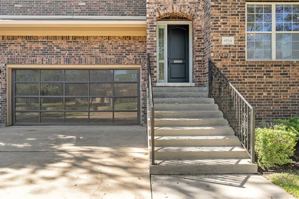 Steps with Wrought Iron Railing lead to the Front Porch.  The House offers a Brick Exterior and Gutters and Downspouts.